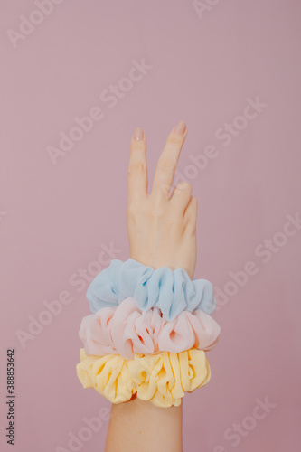 female hand making v sign. with two fingers. Female hand isolated on pink background