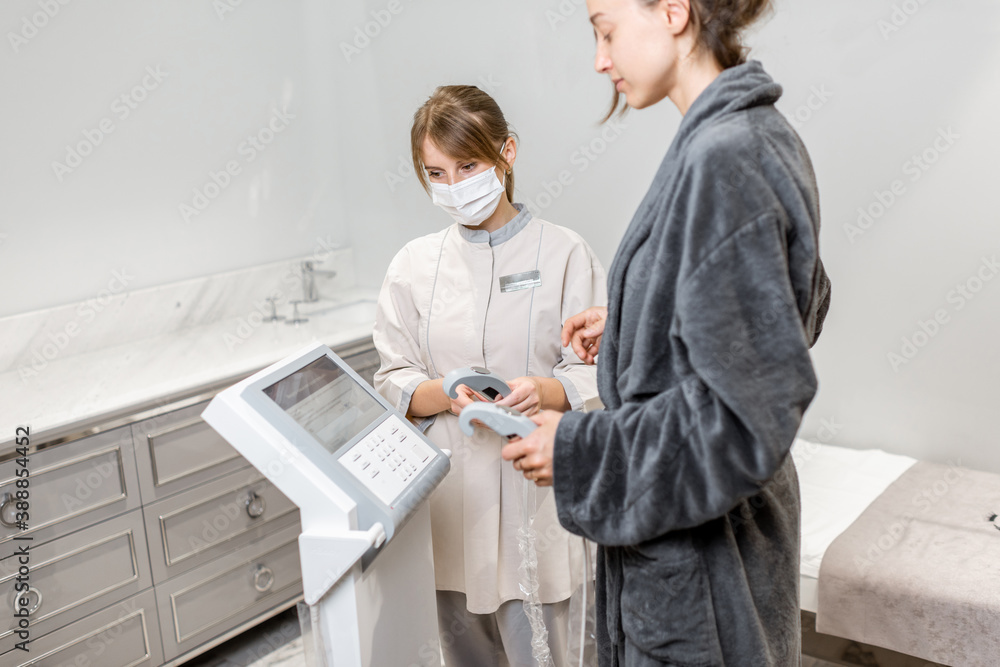Fototapeta premium Woman measuring body composition balance, standing with a medical assistant on the scales during Inbody test at the luxury spa salon