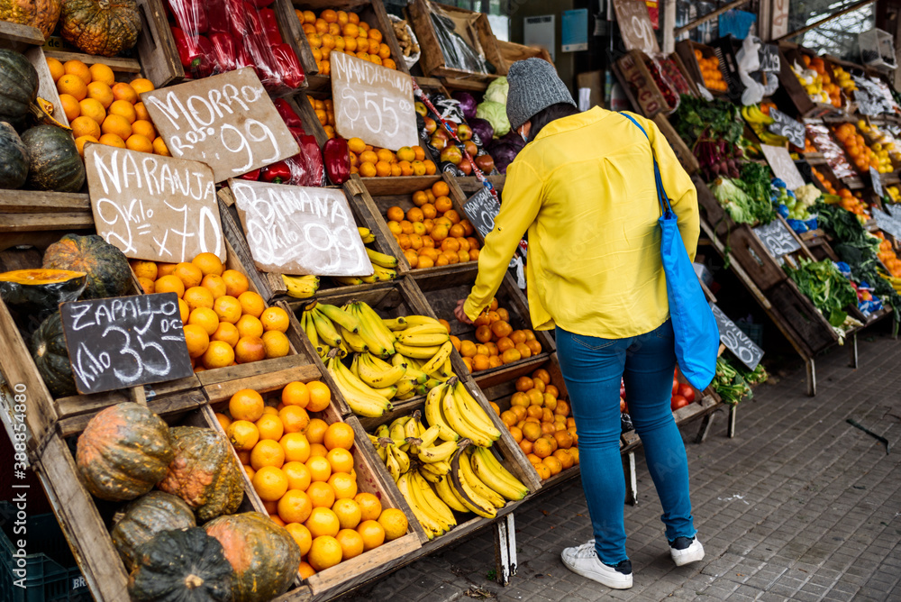 Obraz premium Woman Buying in Street Market