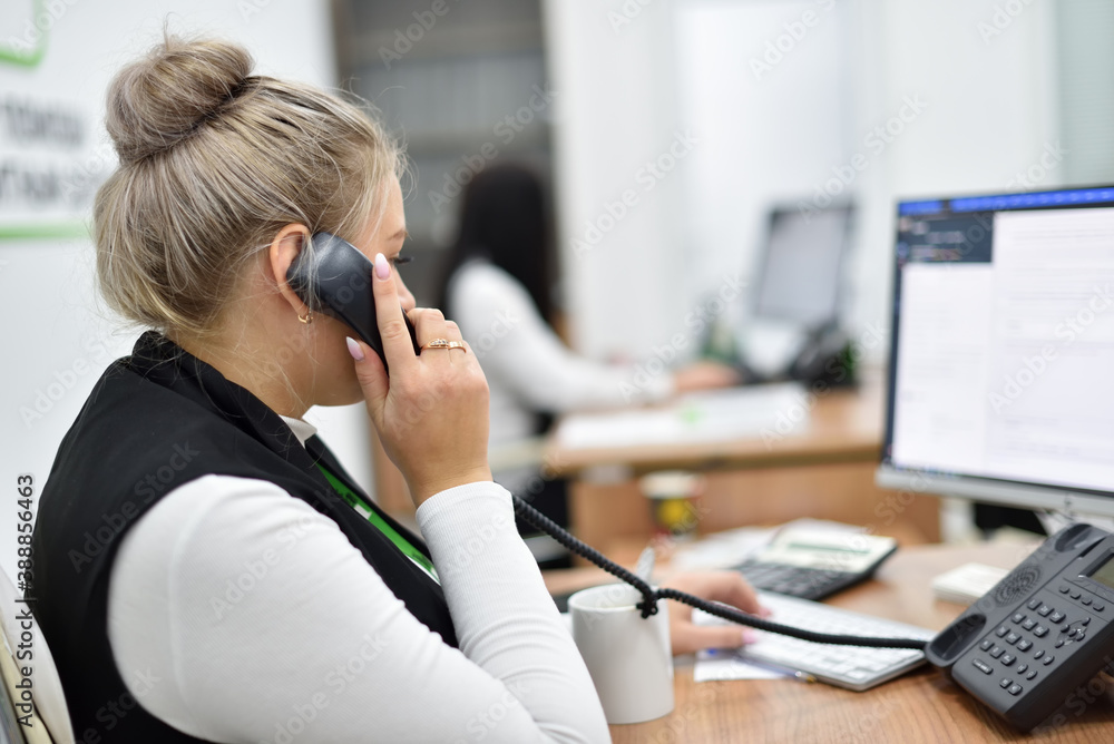 A woman works in the call center and talks on the phone with customers A woman works in the call center and talks on the phone with customers