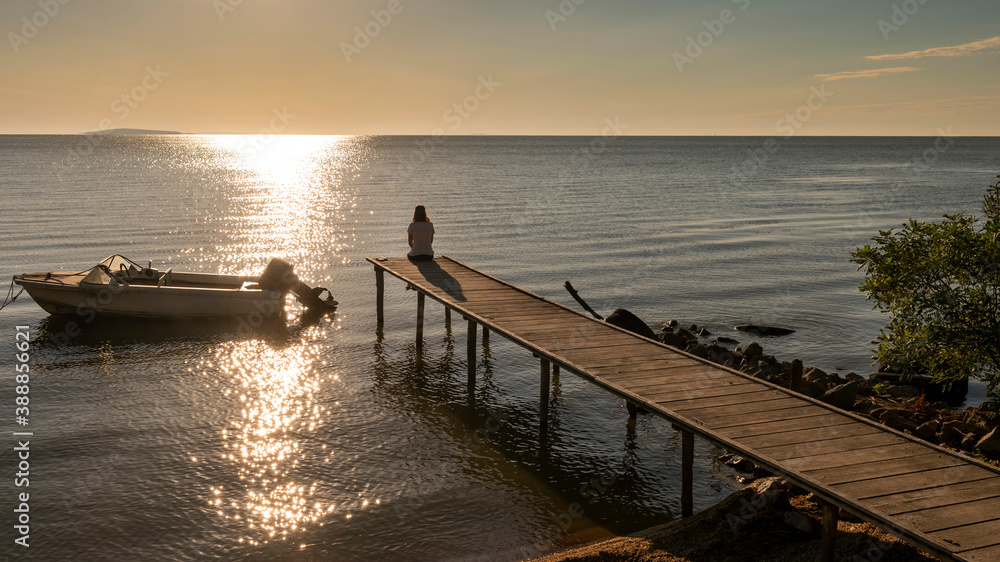 Obraz premium Woman Enjoying Sunset on Pier