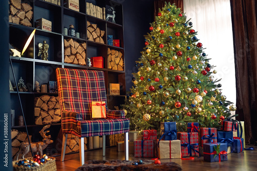 Christmas interior with bookshelves, christmas tree, boxes, chair in studio.