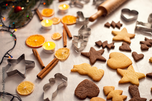 Christmas interior, festive mood, new year decor, baking for holidays. Table full of yellow and brown cookies, baking accessories and cooking ingredients.