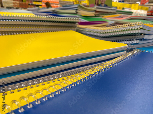 close up of big notebooks with spirals on the market. Schools supplies for the students. Yellow and blue notebooks for sale. © Caner