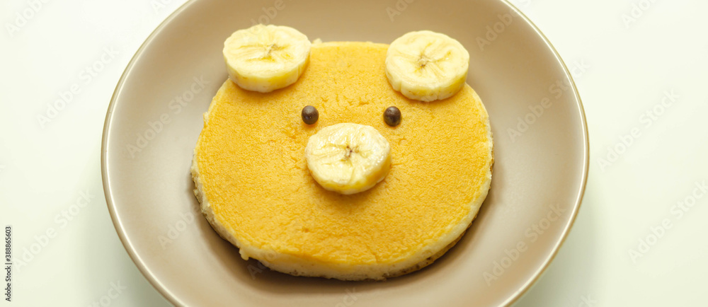 Creative meal for a child, pancake with banana and chocolate  in a face little bear  shape