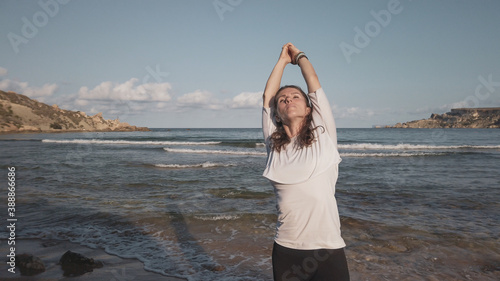 Young caucasian brunette woman doing youga on the sandy beach in the morning. High quality photo photo