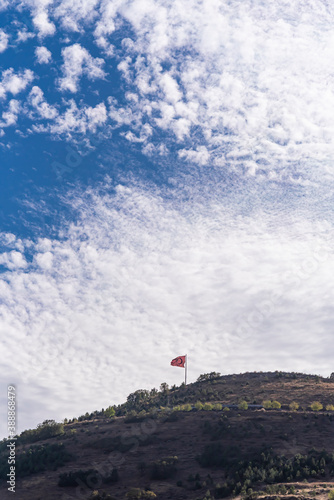 Fototapeta Naklejka Na Ścianę i Meble -  Turkish flag over the hill. with beautiful white clouds and blue sky