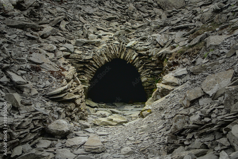 A pitch black entrance to an abandoned mine in the British highlands