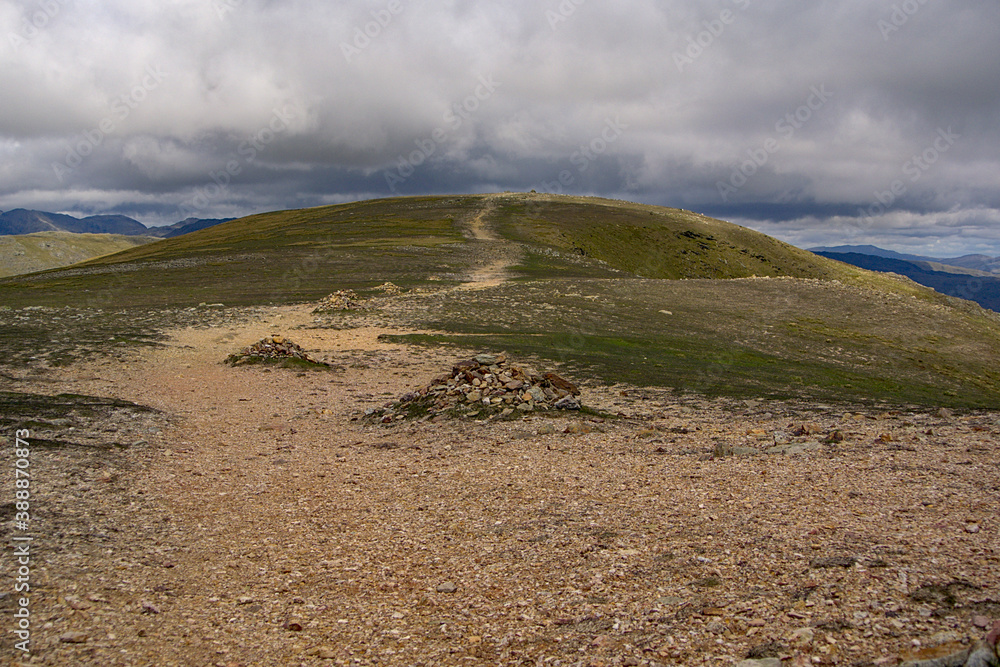 A lone path leading up a single wide hill on a cloudy day