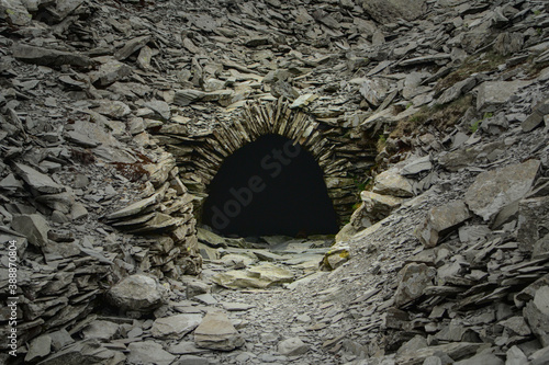 Obraz na płótnie A pitch black entrance to an abandoned mine in the British highlands w salonie