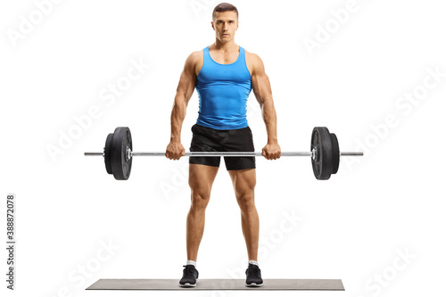 Full length portrait of fit young man in sportswear lifting weights