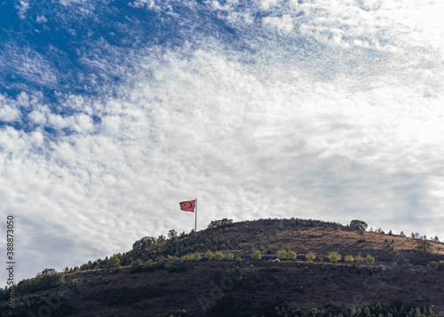 Turkish flag over the hill. with beautiful white clouds and blue sky