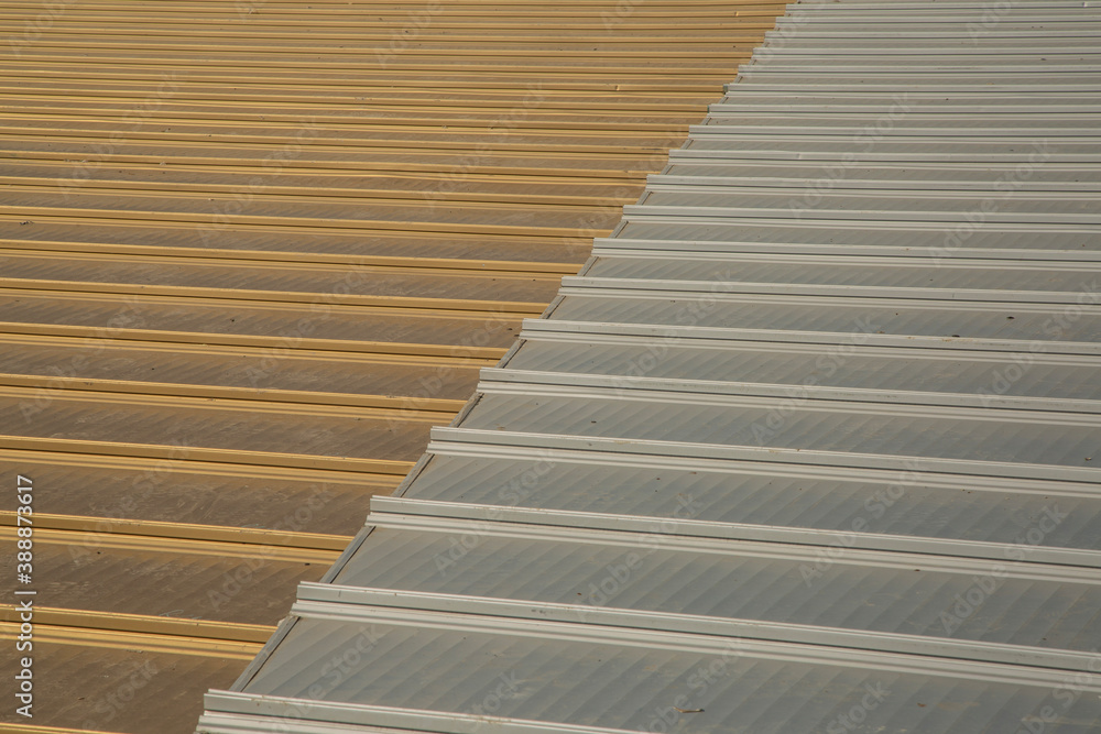 Metallic aluminum sheets in steel and gold color on the roof. close-up Metallic aluminum sheets in steel and gold color on the roof. close-up