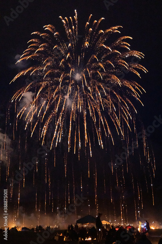 large fireworks display over a crowd of anonymous people