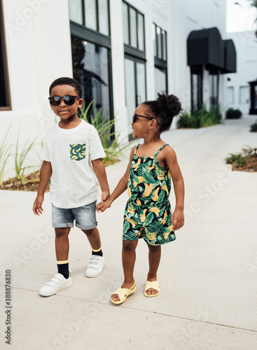 Brother and Sister in matching outfits hugging and holding hands photo