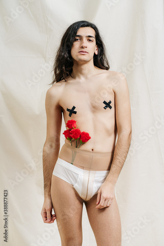 Sexy androgynous model with flowers in tights