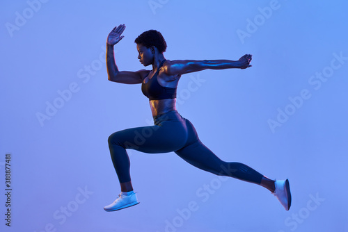Powerful black athlete leaping during workout photo