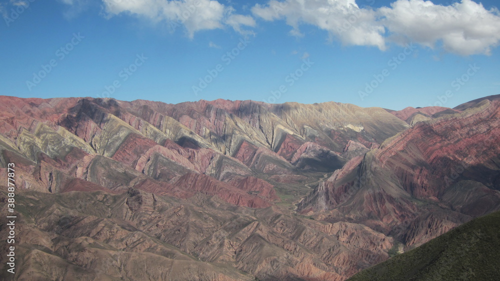 Vista de una montaña  con la tierra de múltiples colores, durante el atardecer .