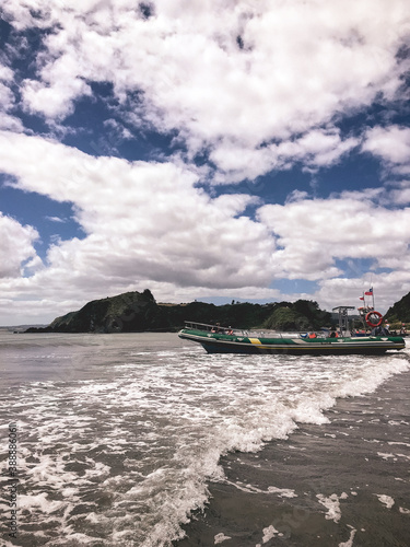 Beautiful beach in the morning in a sunny day and a alone boat with chilean flag