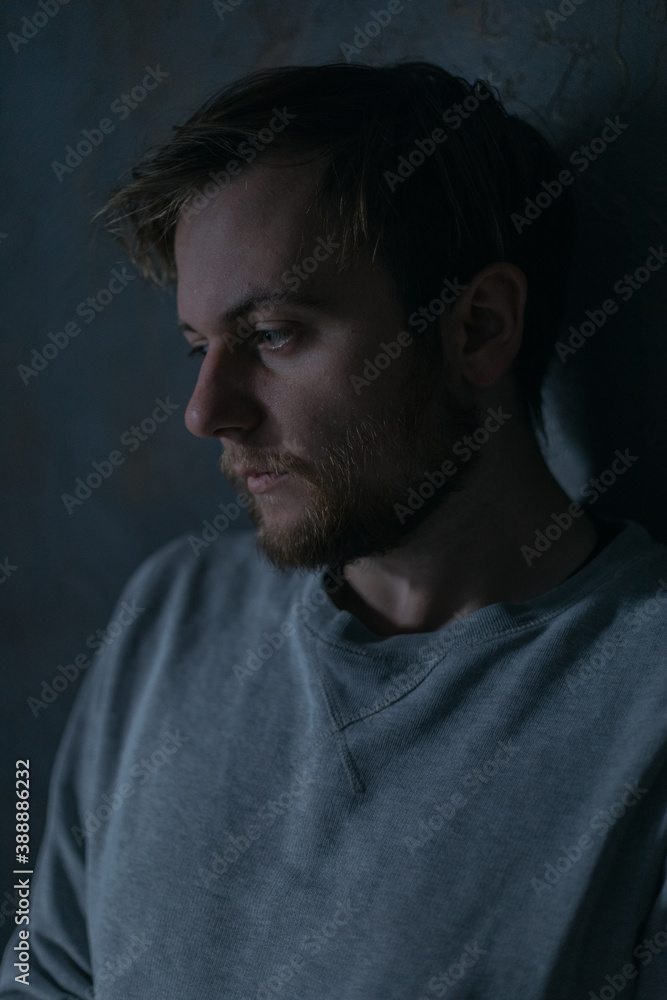 portraits of a guy in a depressed mood at home by a window in a dim light portraits of a guy in a depressed mood at home by a window in a dim light
