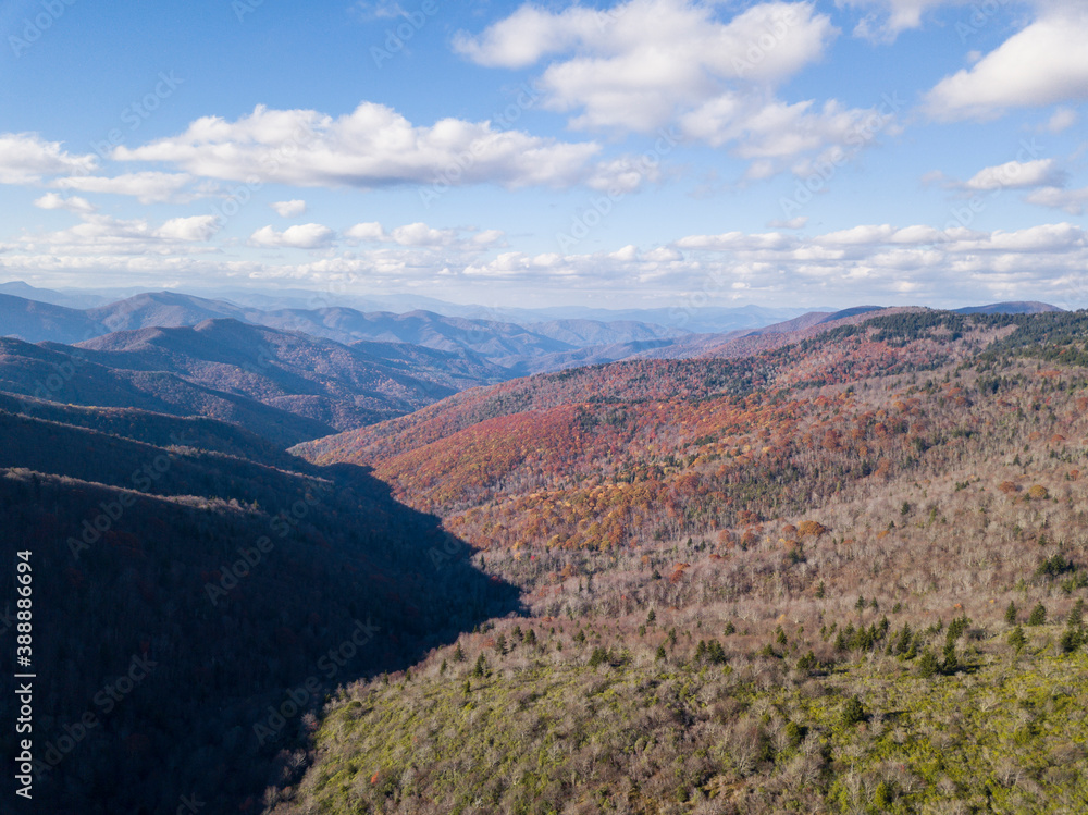 An Aerial view of the Blue Ridge Mountains of North Carolina during autumn with patches of colorful foliage.