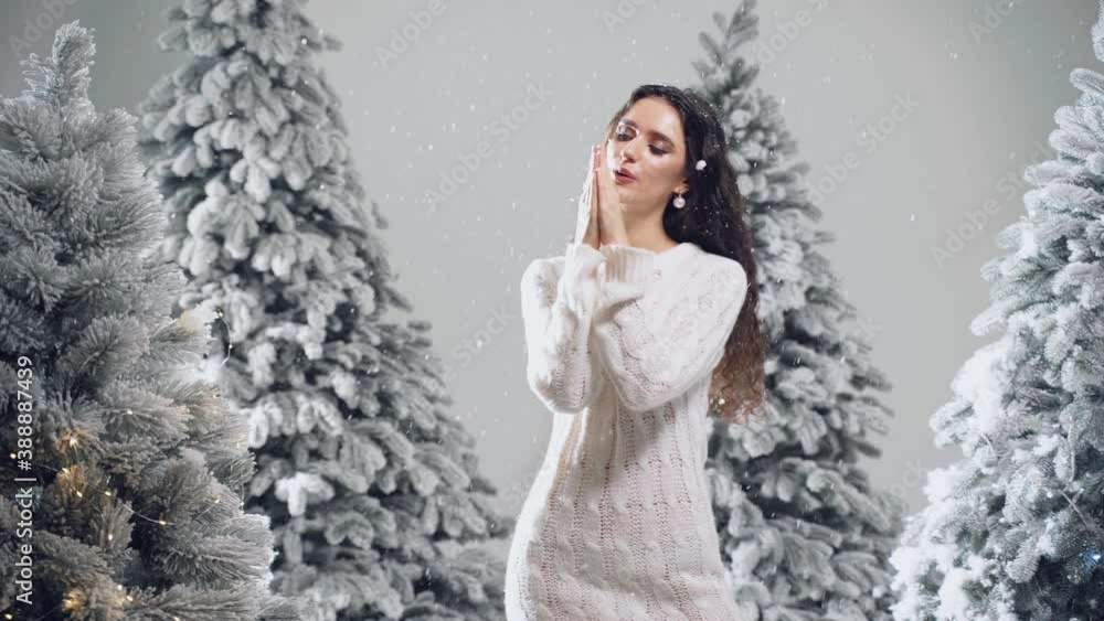 New year celebration.Happy girl with falling snow. Young woman weared in a warm white pullover and white socks. Winter holidays in snowy day New year celebration.Happy girl with falling snow. Young woman weared in a warm white pullover and white socks. Winter holidays in snowy day
