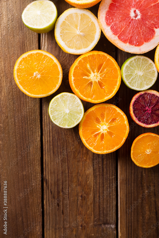 Citrus fruits on a wooden background. Slices of orange, lemon, grapefruit, mandarin, lime. Mixed festive colorful tropical and citrus fruit Healthy eating photo concept. Copyspace Citrus fruits on a wooden background. Slices of orange, lemon, grapefruit, mandarin, lime. Mixed festive colorful tropical and citrus fruit Healthy eating photo concept. Copyspace
