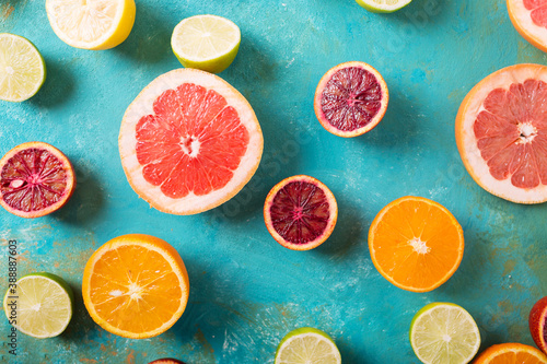 Citrus fruits on turquoise abstract background. Slices of orange, lemon, grapefruit, mandarin, lime. Mixed festive colorful tropical and citrus fruit sliced. Healthy eating photo concept. Copyspace photo