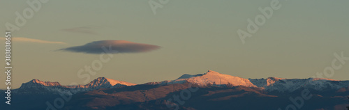 Panoramic view of Sierra Nevada at sunset in autumn with a lonely cloud over it