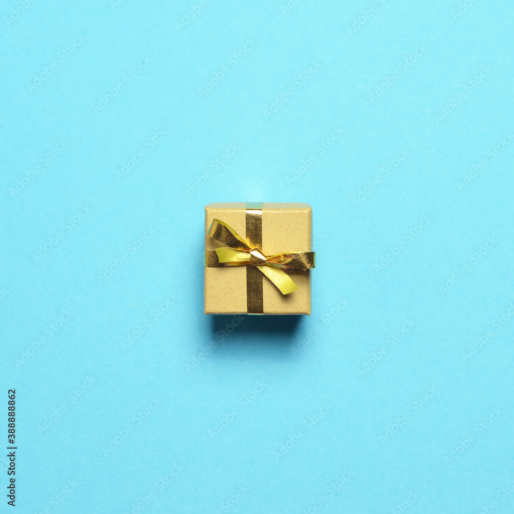 Christmas gift with golden ribbon on pastel blue background Christmas gift with golden ribbon on pastel blue background