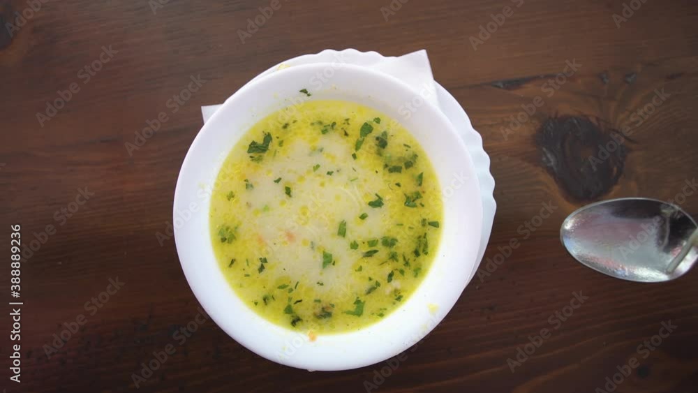 Eating a Chicken soup with green onion and croutons in bowl, pov top view Eating a Chicken soup with green onion and croutons in bowl, pov top view