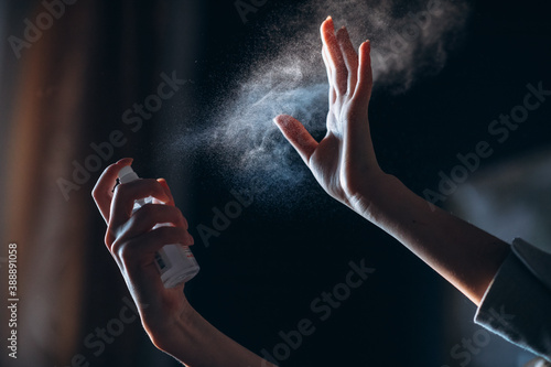 Person pressing on antiseptic and cleaning hands at air. photo