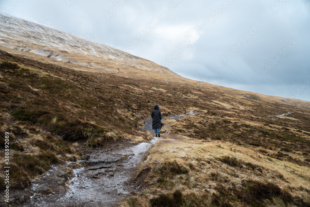 Young woman walking away on a trail, Faroe islands Young woman walking away on a trail, Faroe islands
