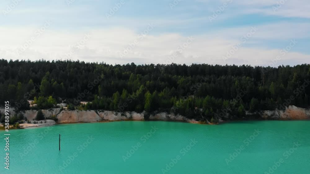 Happy couple holding hands and running to the cliff - a landscape of blue lake and forest Happy couple holding hands and running to the cliff - a landscape of blue lake and forest