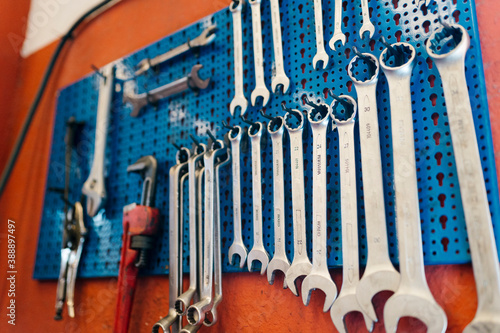 Close-up of work tools hanging on pegboard in workshop photo