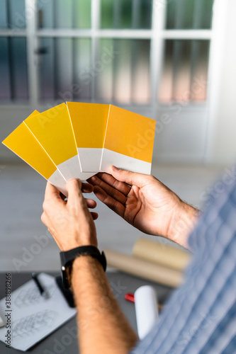 Architect holding color swatch while standing at office