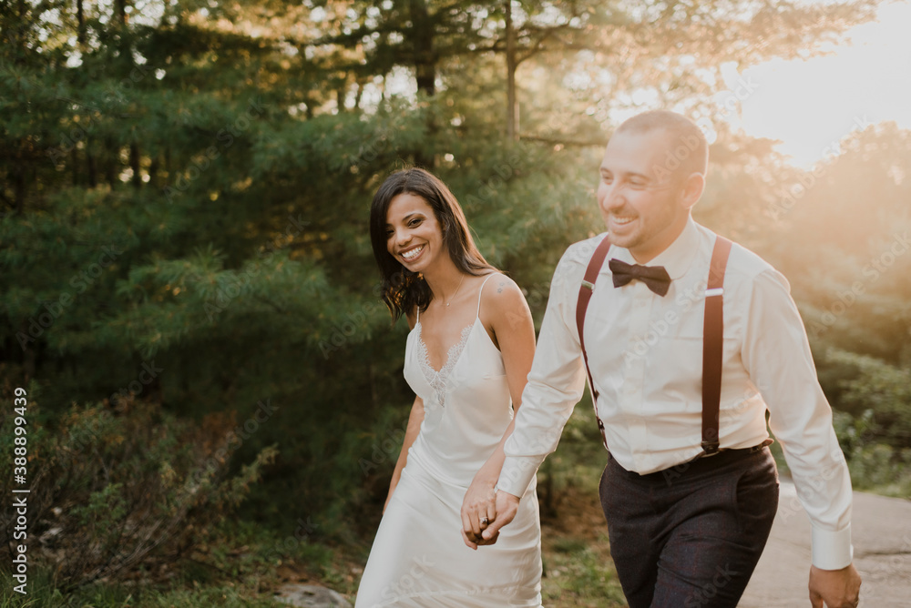 Smiling couple holding hands while walking in forest Smiling couple holding hands while walking in forest