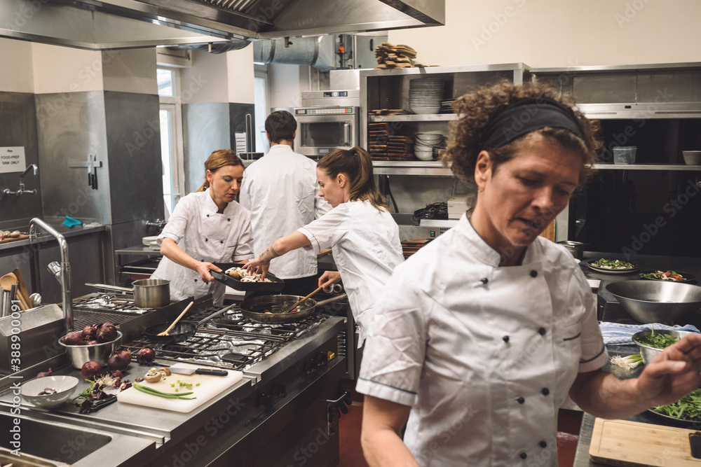 Chefs preparing food in kitchen at restaurant Chefs preparing food in kitchen at restaurant