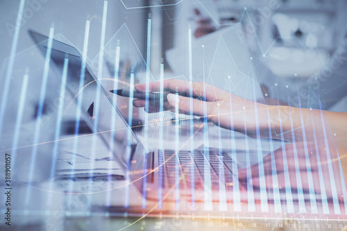 Multi exposure of woman hands typing on computer and financial graph hologram drawing. Stock market analysis concept.