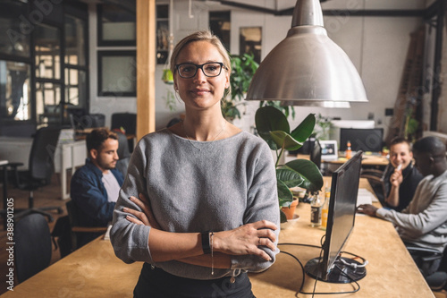 Portrait of businesswoman with arms crossed at workplace photo