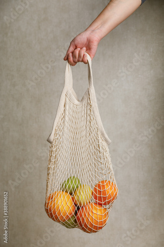 woman holding mesh shopping bag. 