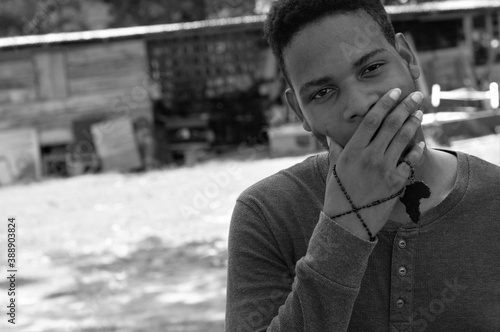 Photography Portrait of a young black boy with an African symbol wrapped abound his hand