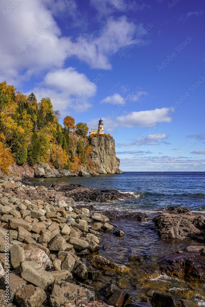 Split Rock Lighthouse on clear blue sky with puffy white clouds