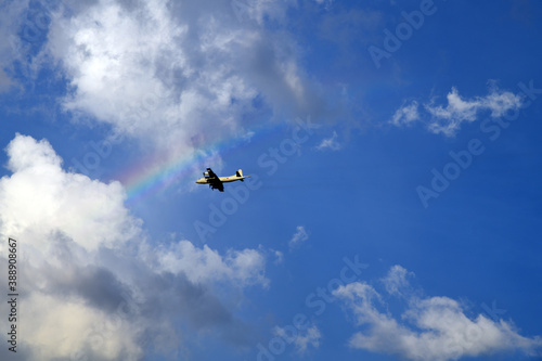 虹と飛行機。空の背景素材