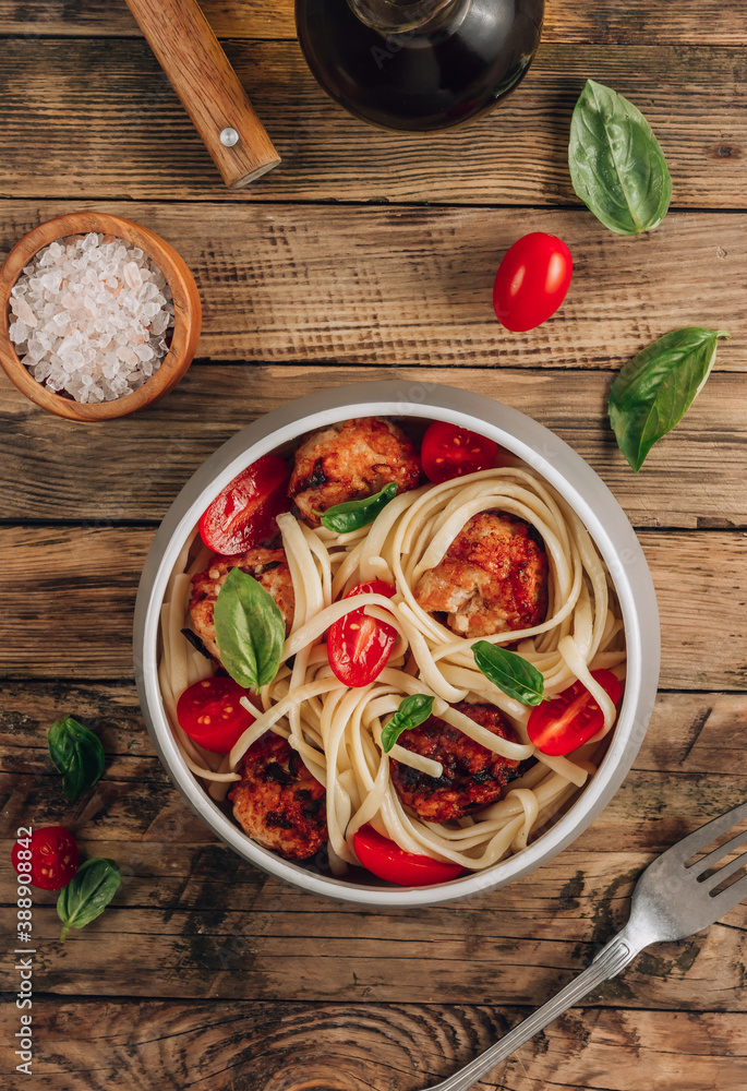 Italian pasta with chicken meatballs, tomatoes and basil.