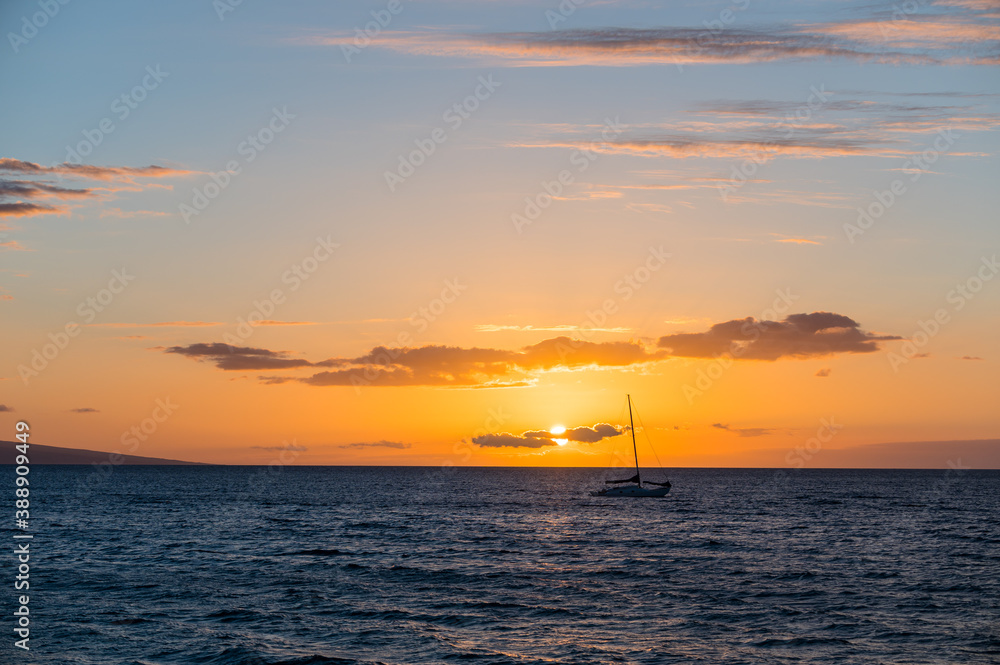 Silhouette of a boat in the Maui coast right before sunset. Hawaii, USA.