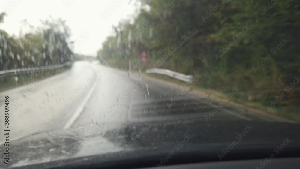 Road view through car window with rain drops, Driving in rain. Road view through car window with rain drops, Driving in rain.