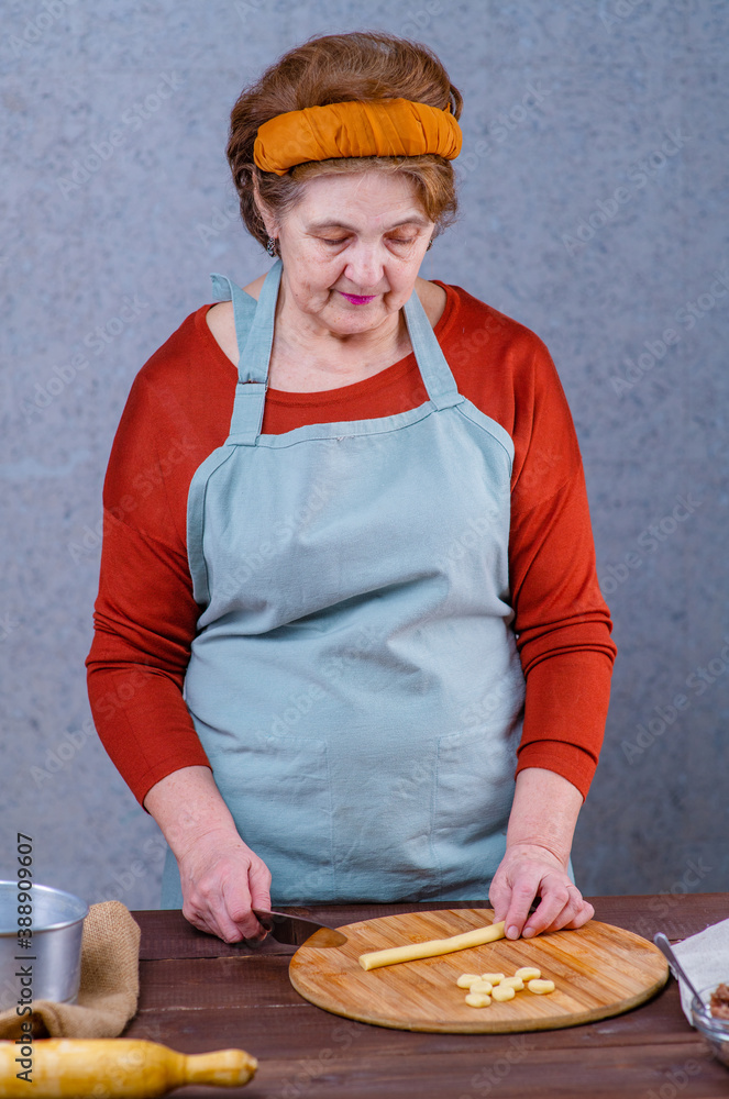 Female cook sculpts dumplings with her hands, looks into the frame and smiles. Female cook sculpts dumplings with her hands, looks into the frame and smiles.