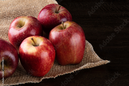 Red apples in basket with wooden background.