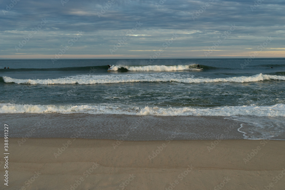 Surfers share a wave at sunset Surfers share a wave at sunset